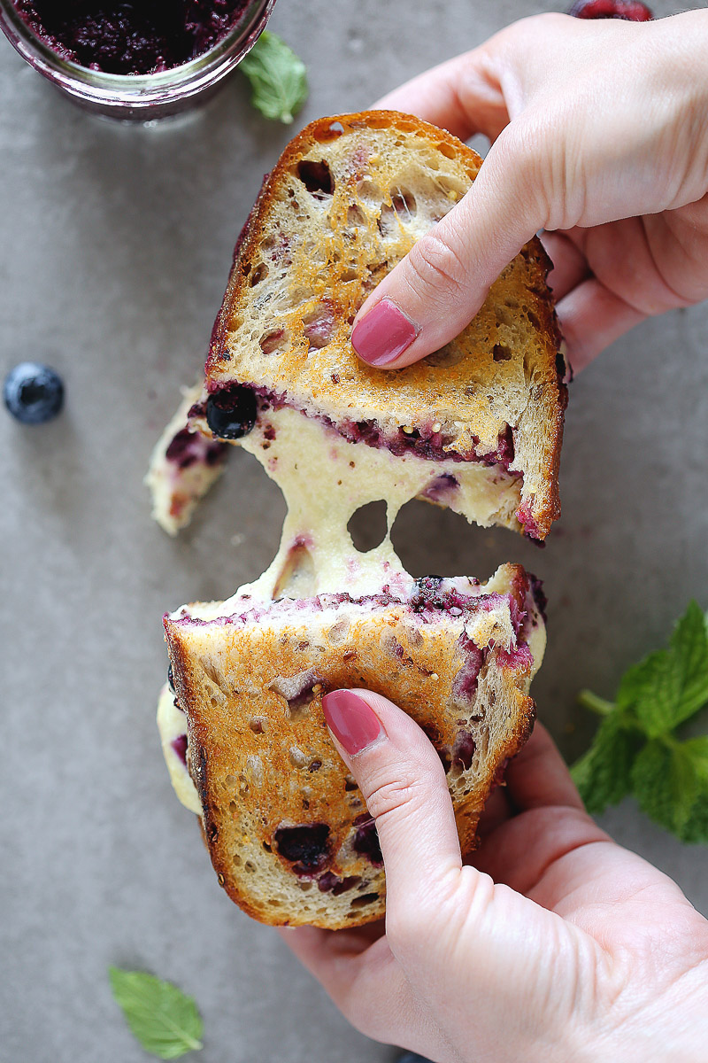 Blueberry Mint Grilled Cheese by Pasta-based. A gooey grilled cheese sandwich being pulled apart with mozzarella cheese stretching between each half.