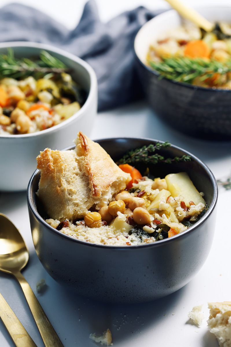 Chickpea Soup by Pasta-based. Hearty, warm, vegetable-filled, chunky, fortifying soup with carrots, celery, leeks, potatoes, garlic, kale, and chickpeas. A piece of crusty bread in the bowl is perfect for dipping.