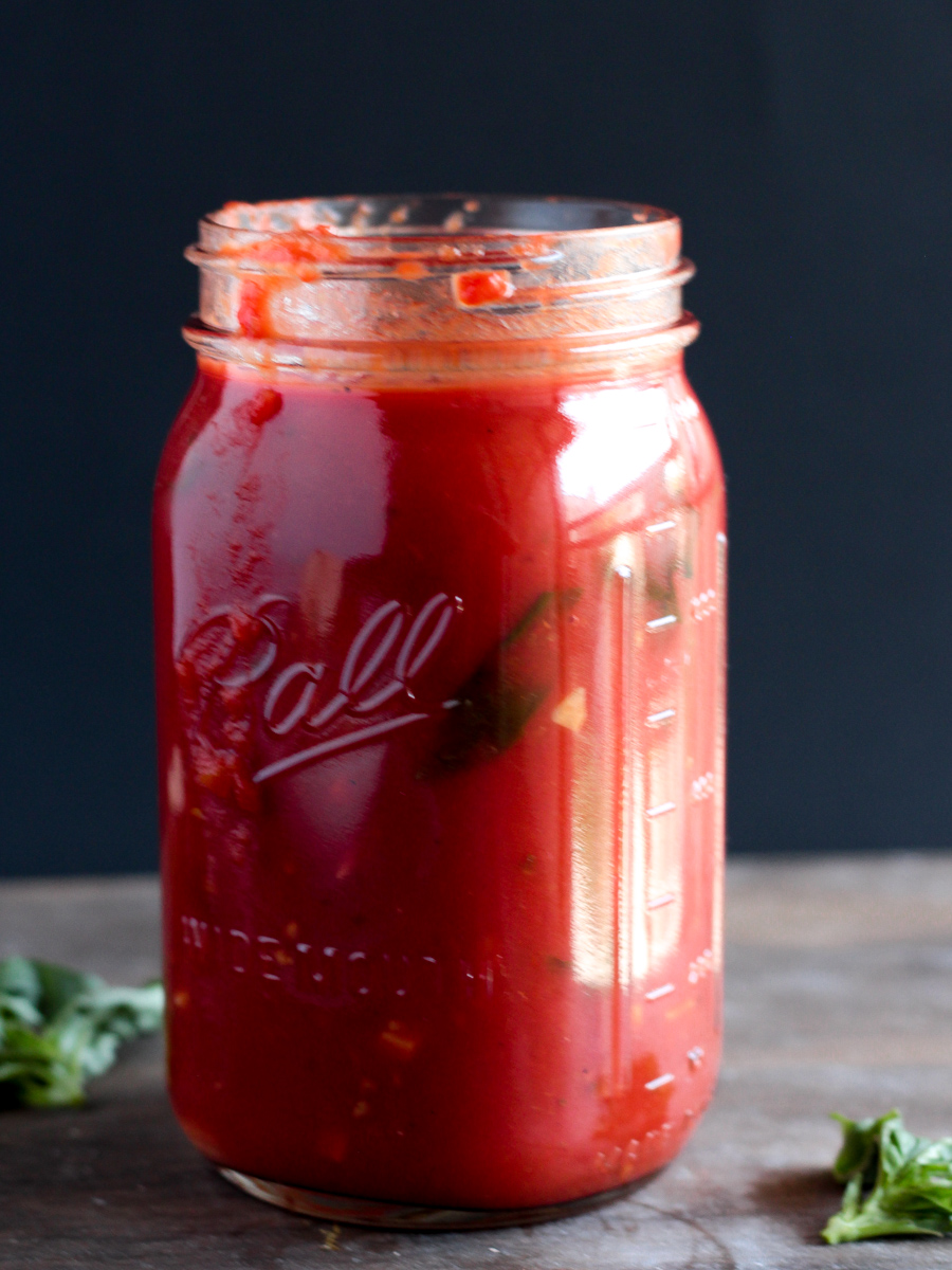 Jar filled with tomato sauce, side shot.