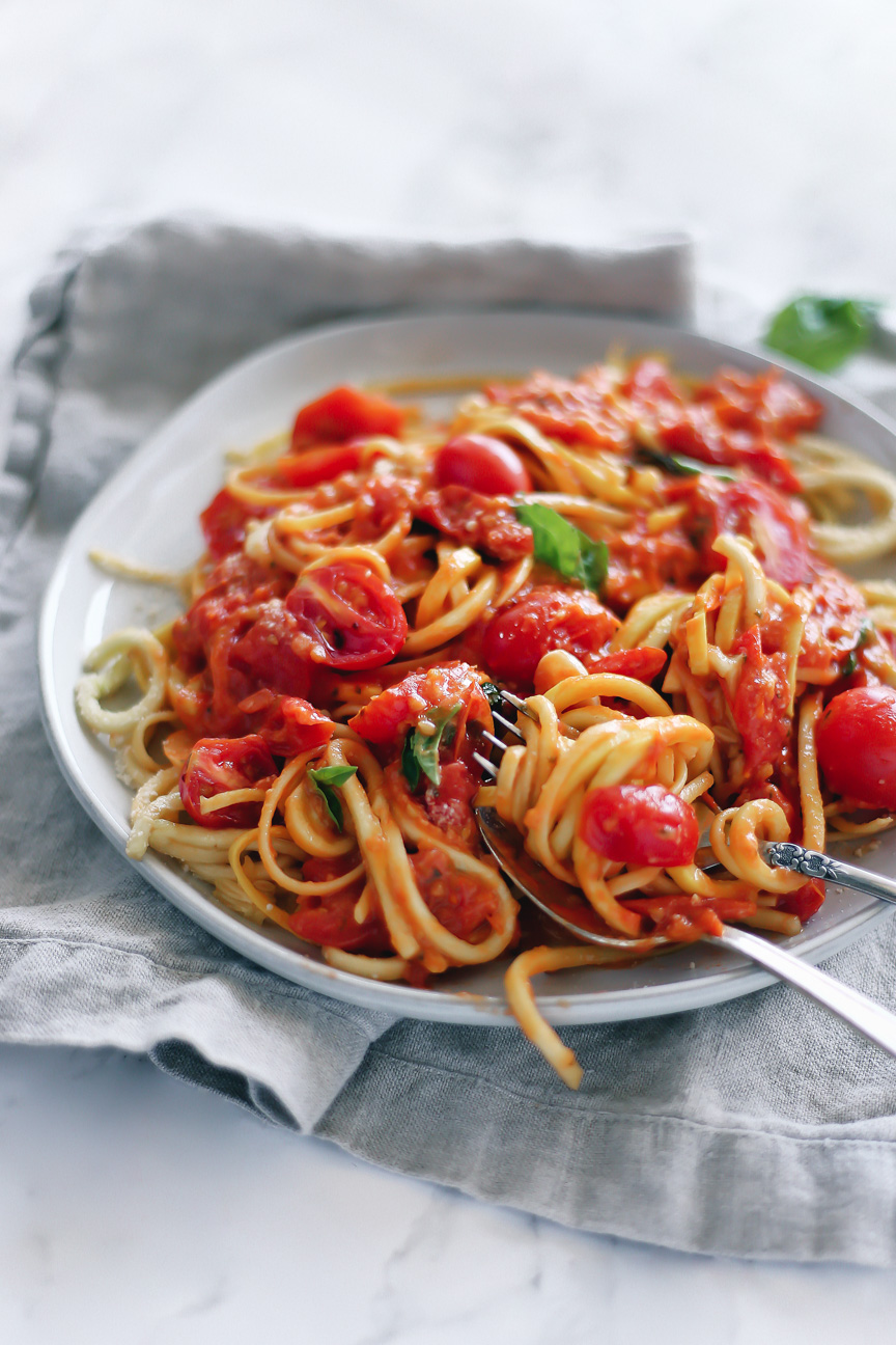 a mix of wheat spaghetti and yellow squash noodles mixed with juicy grape tomato sauce.