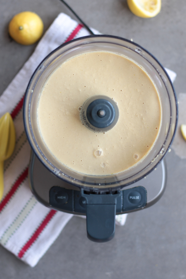 Easy White Wine Alfredo Sauce.  Overhead photo of open food processor, post blending.  Creamy, white sauce is the product inside the food processor.