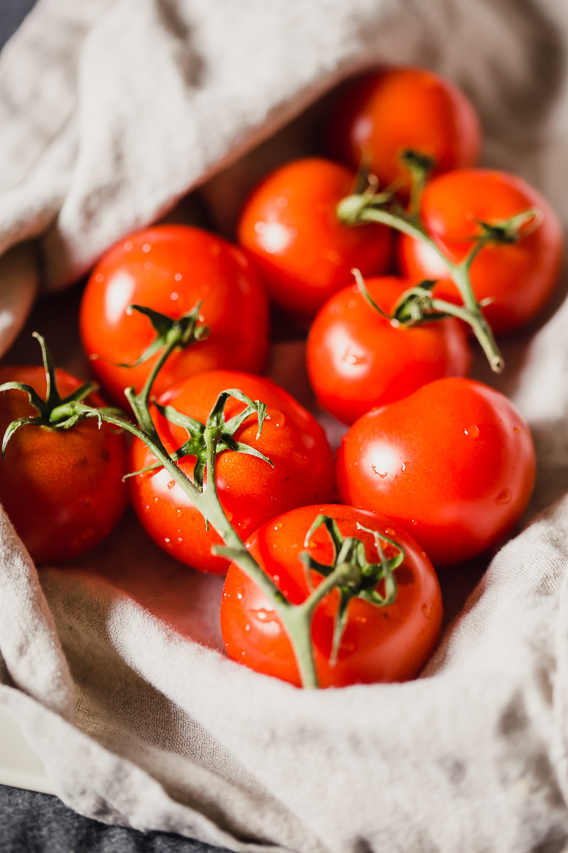 Oven Roasted Campari Tomatoes by Pasta-based. Beautiful bright red campari tomatoes on the vine, washed and wrapped in a linen towel.