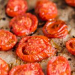 Oven Roasted Campari Tomatoes by Pasta-based. Bright red, roasted campari tomatoes straight out of the oven. Round slices of campari tomatoes drizzled with olive oil and roasted on parchment paper.