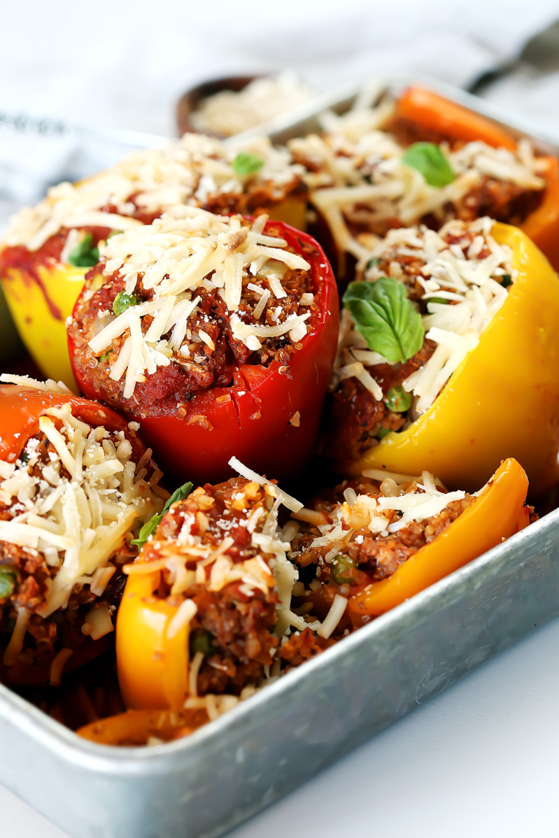 vegan stuffed peppers by pasta-based. six stuffed peppers together in a silver pan.