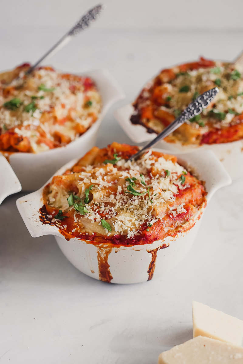 Vegan Baked Ziti by Pasta-based. Cheesy, saucy, creamy baked ziti bubbling over a small crockpot sprinkled with vegan parmesan and fresh parsley.