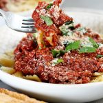 Vegan Cauliflower Walnut Bolognese by Pasta-based. Detailed view of a forkful of cauliflower walnut bolognese sauce with farfalle pasta.