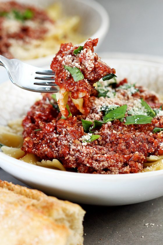 Vegan Cauliflower Walnut Bolognese by Pasta-based. Detailed view of a forkful of cauliflower walnut bolognese sauce with farfalle pasta.