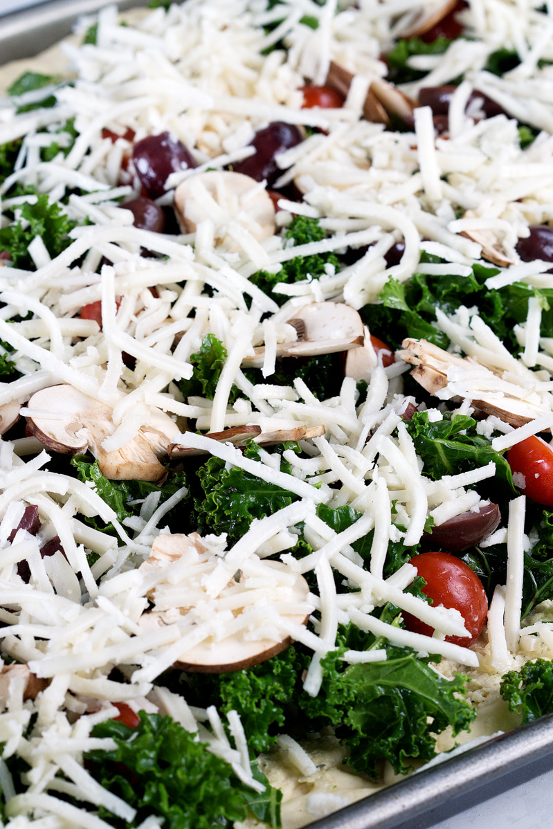 Vegan Crispy Kale Grandma-Style Pizza by Pasta-based. A close-up of the pizza before going into the oven.