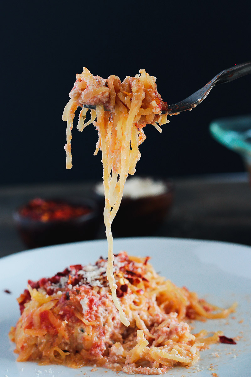 Spaghetti Squash Lasagna (Vegan and Gluten-free) by Pasta-based. A big forkful of spaghetti squash lasagna with the squash noodles cascading down onto the plate.