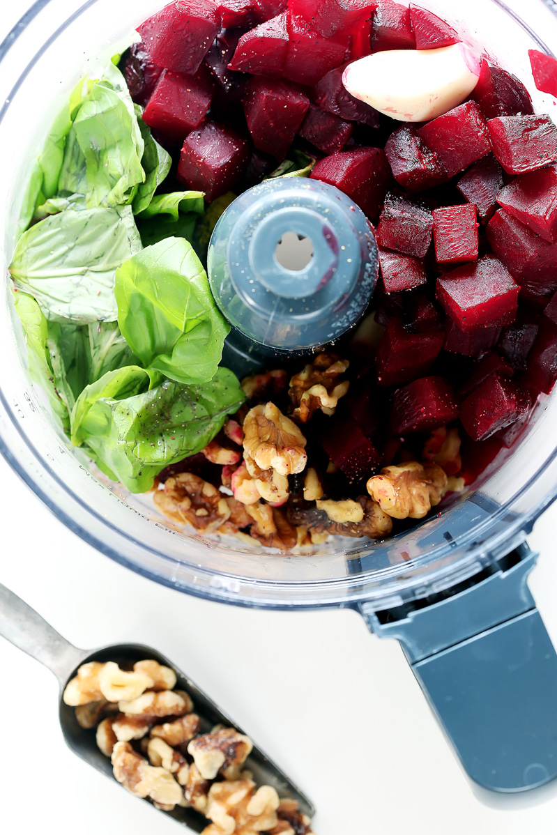 Vegan Red Beet Pesto Ravioli by Pasta-based. Ingredients in a food processor: fresh basil, fresh garlic cloves, raw walnuts, and roasted beets.