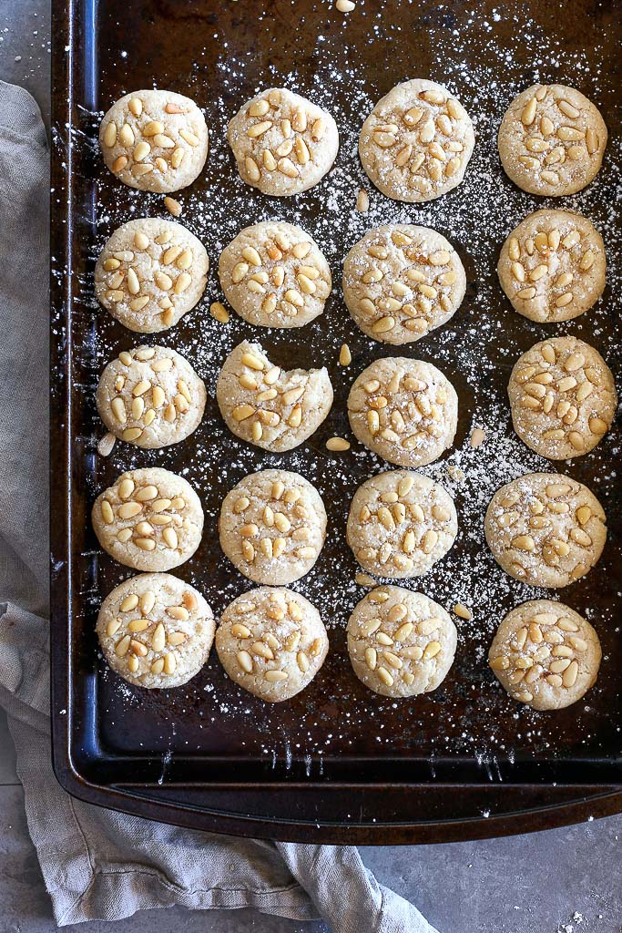 An overhead shot of the baking sheet with the pignoli cookies lined up and deliciously baked.