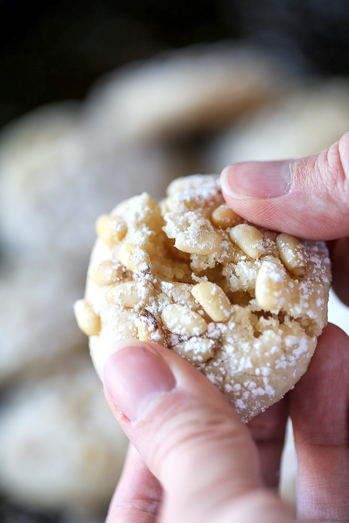 Someone is gently breaking a chewy, soft cookie in half.