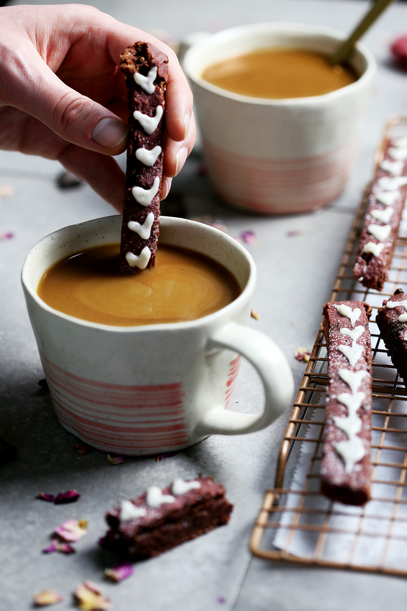 Red Velvet Biscotti by Pasta-based. Dipped into coffee, red velvet biscotti with white icing hearts.