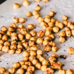 Crispy chickpeas scattered on a baking sheet.