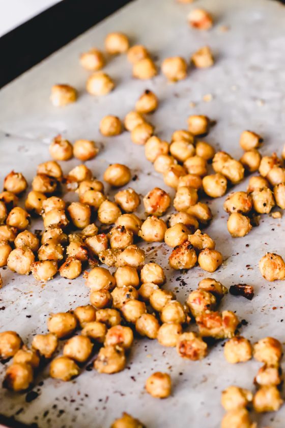 Crispy chickpeas scattered on a baking sheet.