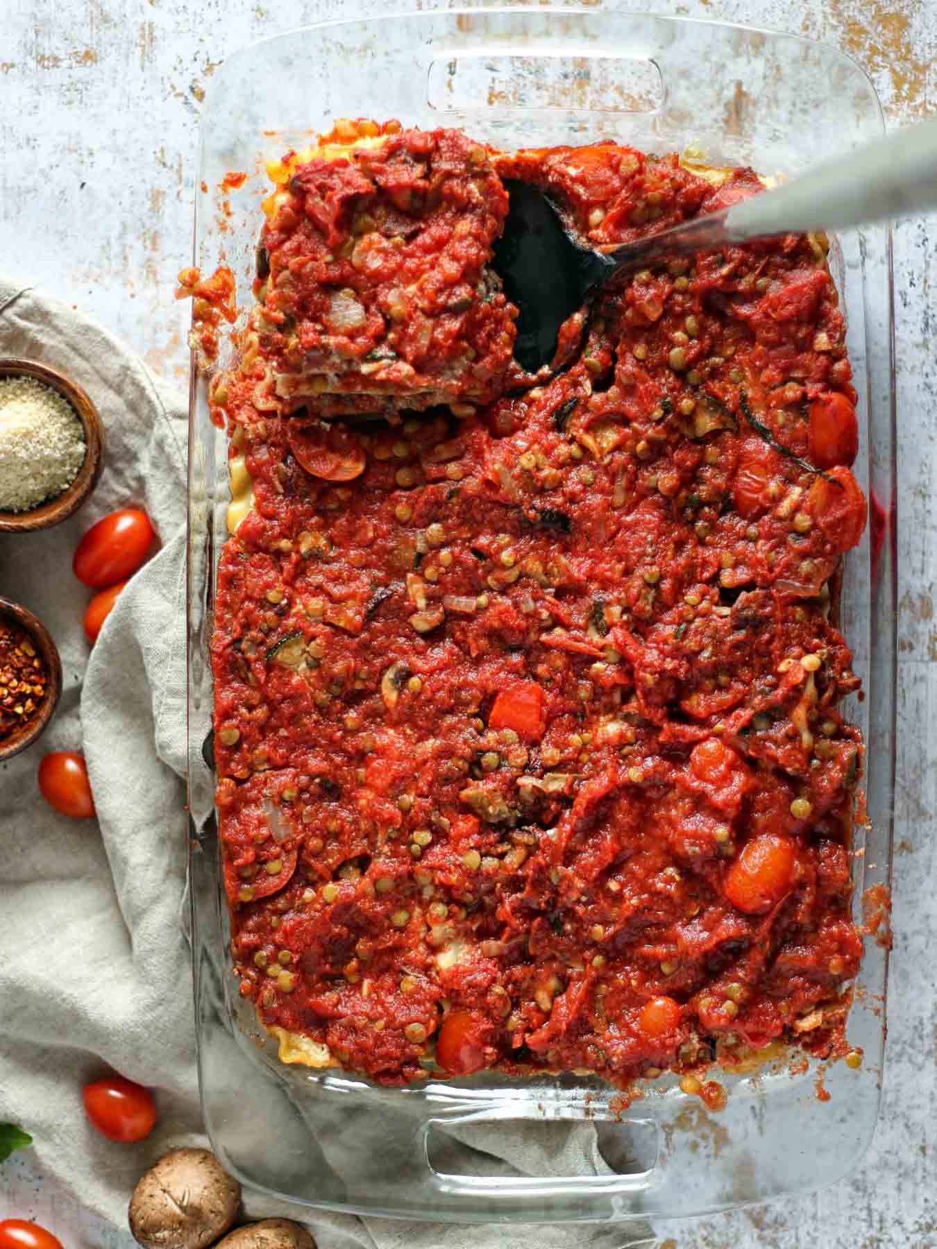 The vegan lasagna consists of four layers: our homemade lentil bolognese sauce, cooked lasagna noodles, homemade almond ricotta cheese and roasted vegetables (eggplant, zucchini, and red pepper)